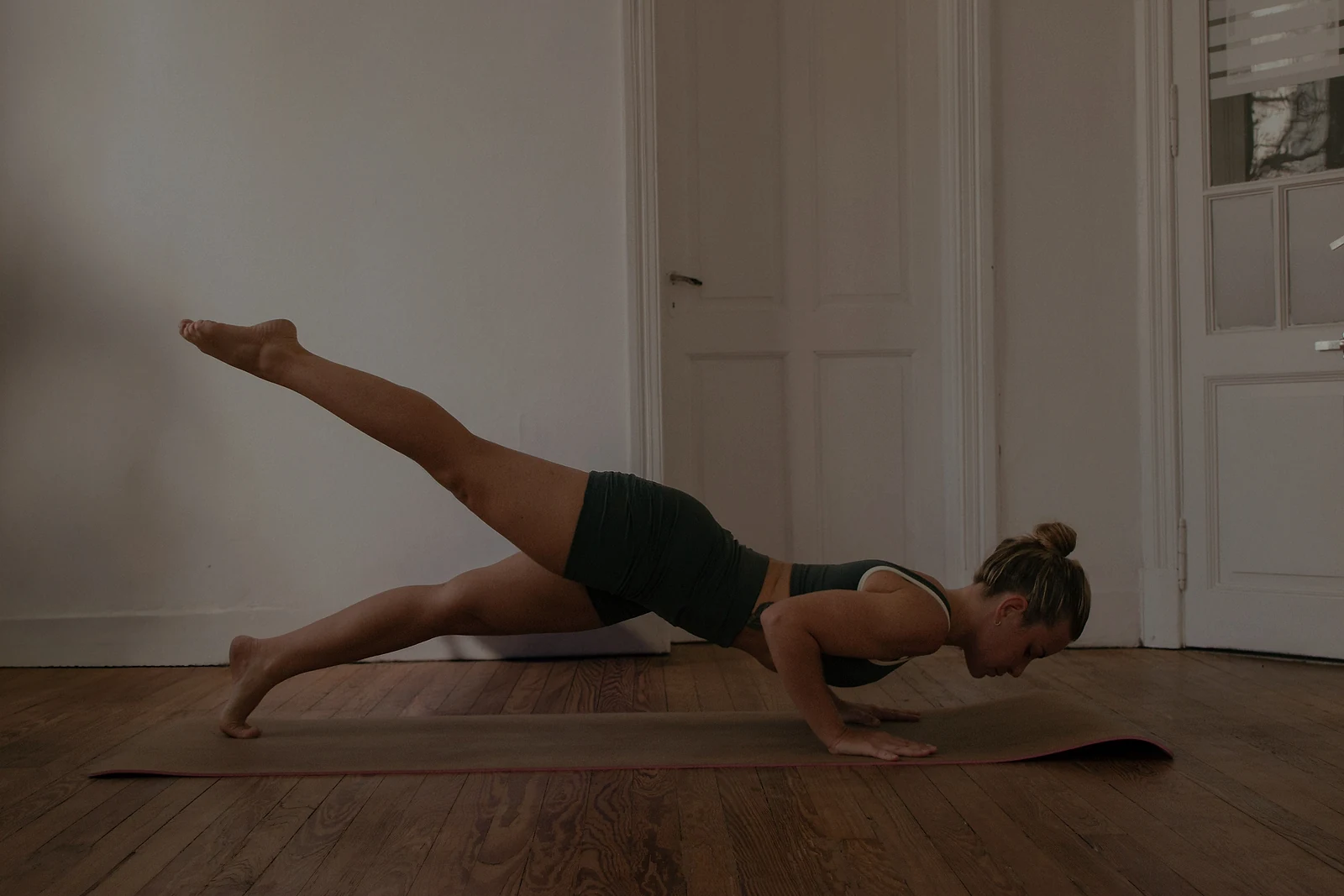 Sami en una postura de equilibrio y fuerza sobre el mat.